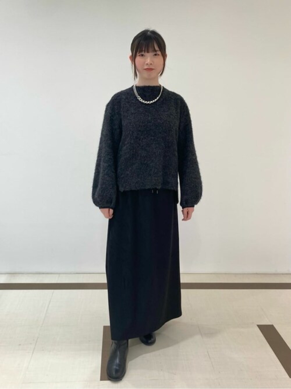 グレー系のTシャツ/カットソー、ブラック系のスカートを着用したレディースの冬コーディネートの1枚目の写真