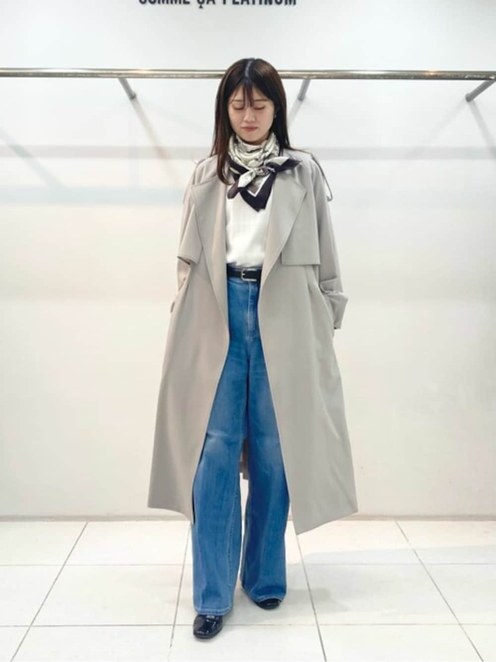 ベージュ系のトレンチコート、ホワイト系のニット/セーターを着用したレディースの冬コーディネートの1枚目の写真