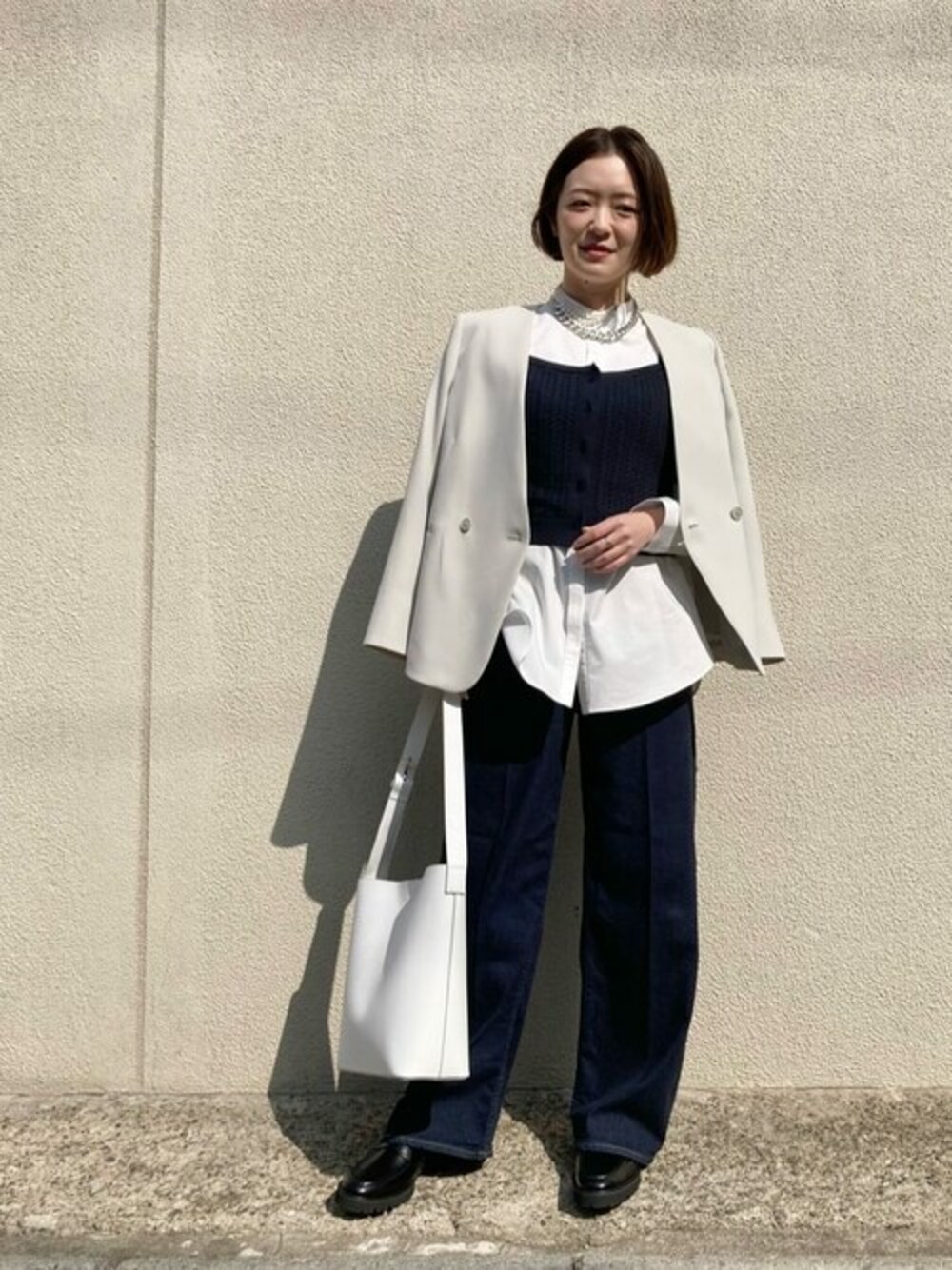グリーン系のスーツジャケット、ホワイト系のシャツ/ブラウス、ブルー系のデニムパンツを着用したレディースの春コーディネートの1枚目の写真
