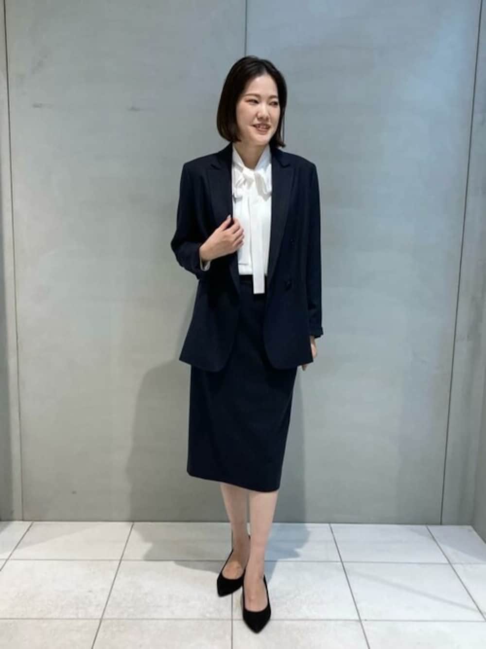 ブルー系のスーツジャケット、ブルー系のスカートを着用したレディースの春コーディネートの1枚目の写真
