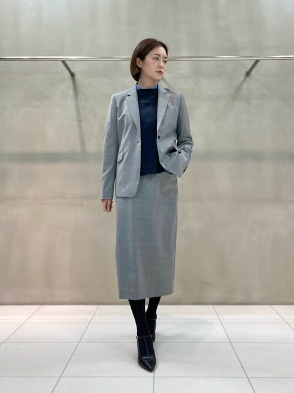 グレー系のスーツジャケット、グレー系のスーツスカート、ブルー系のシャツ/ブラウスを着用したレディースの春コーディネートの1枚目の写真