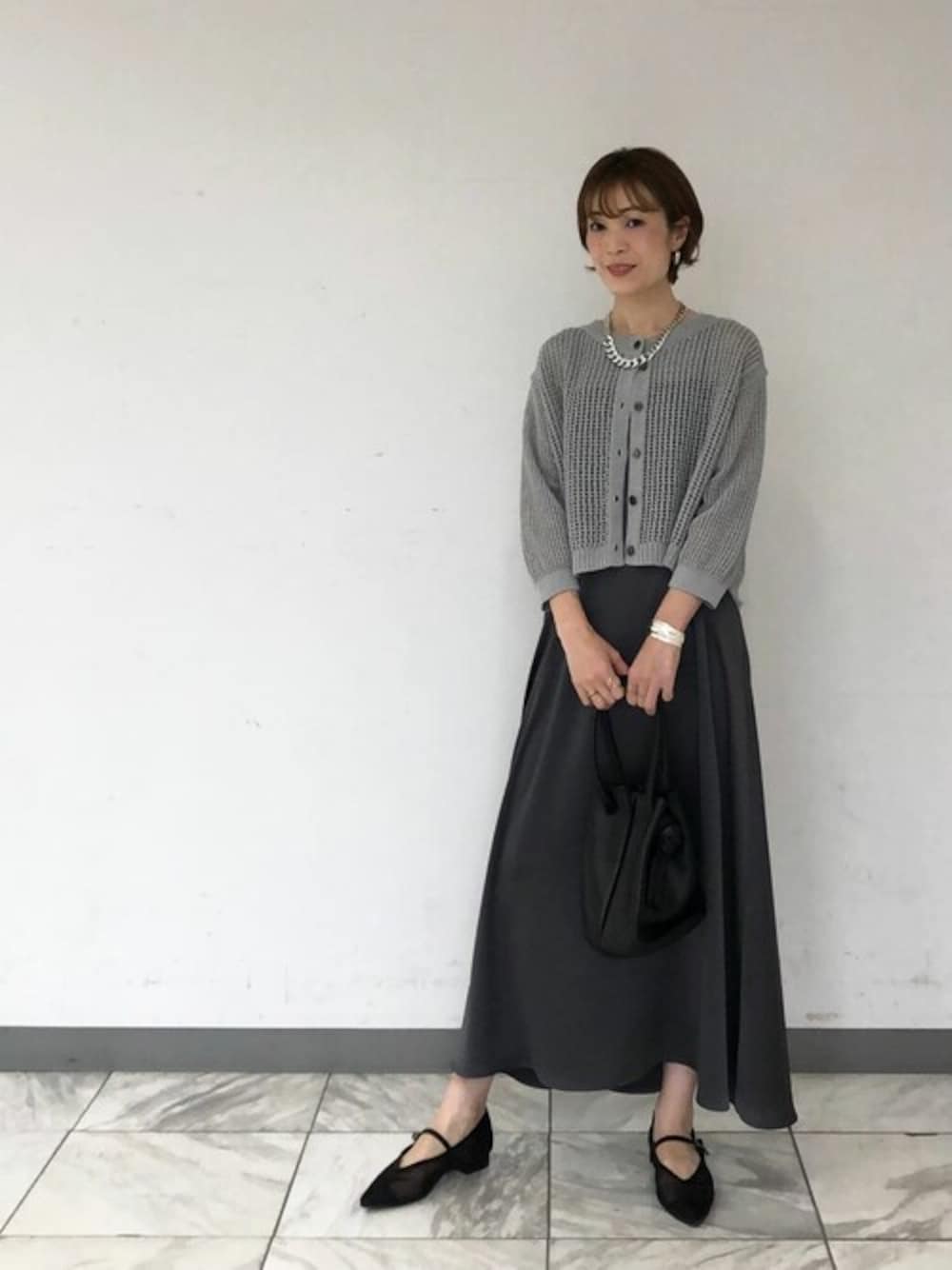 グレー系のワンピースを着用したレディースの春コーディネートの1枚目の写真