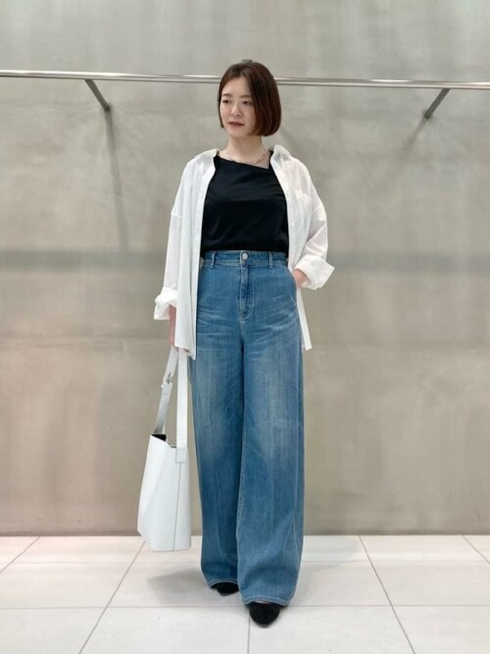 ホワイト系のシャツ/ブラウス、ブラック系のTシャツ/カットソー、ブルー系のデニムパンツを着用したレディースの春コーディネートの1枚目の写真