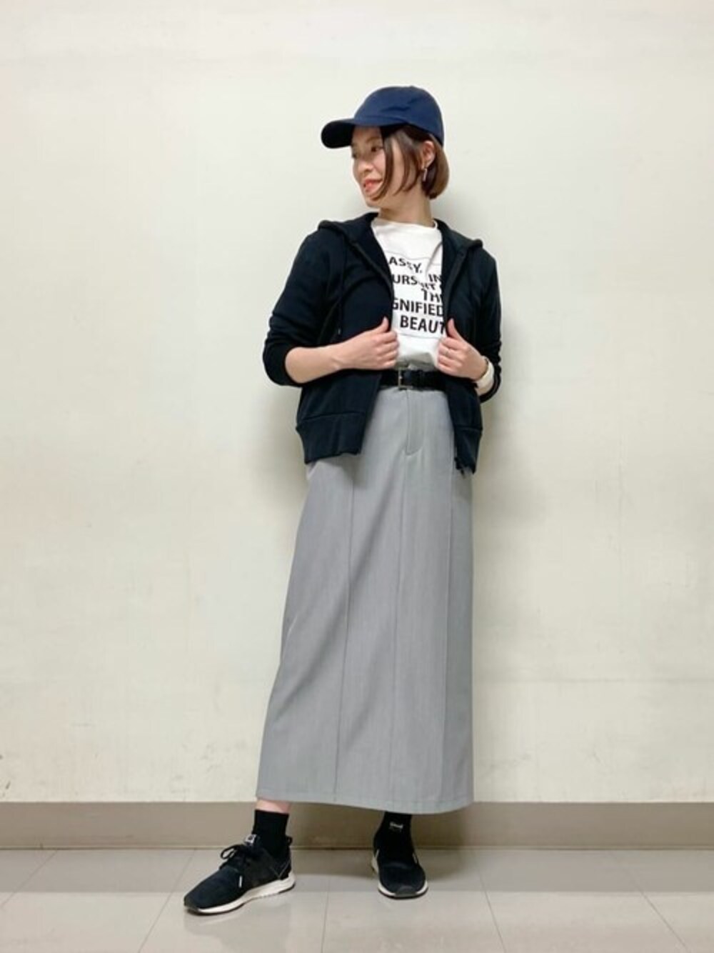 ホワイト系のTシャツ/カットソー、グレー系のスカート、ブラウン系のベルトを着用したレディースの春コーディネートの1枚目の写真