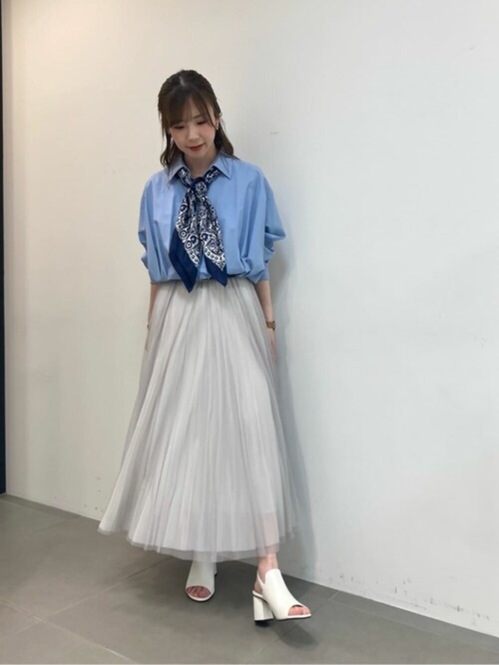 ブルー系のシャツ/ブラウス、グレー系のスカート、ホワイト系のサンダルを着用したレディースの春コーディネートの1枚目の写真