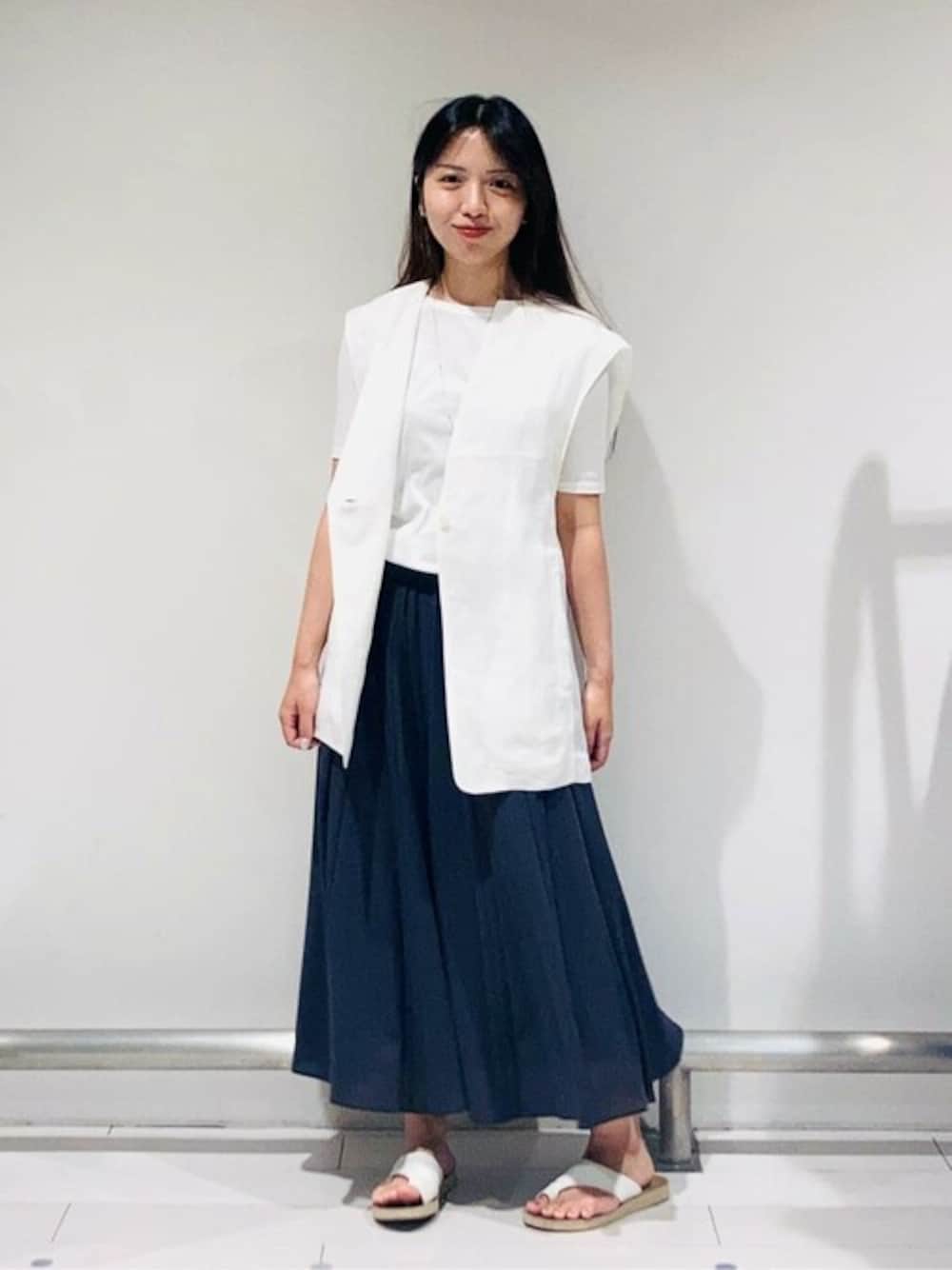 ホワイト系のベスト、ブルー系のスカート、ホワイト系のTシャツ/カットソーを着用したレディースの春コーディネートの1枚目の写真