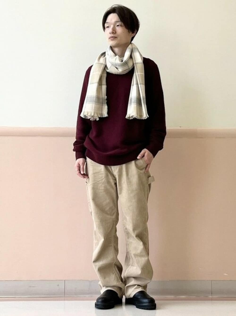 レッド系のニット/セーター、ベージュ系のその他パンツ、グレー系のマフラーを着用したメンズの秋コーディネートの1枚目の写真