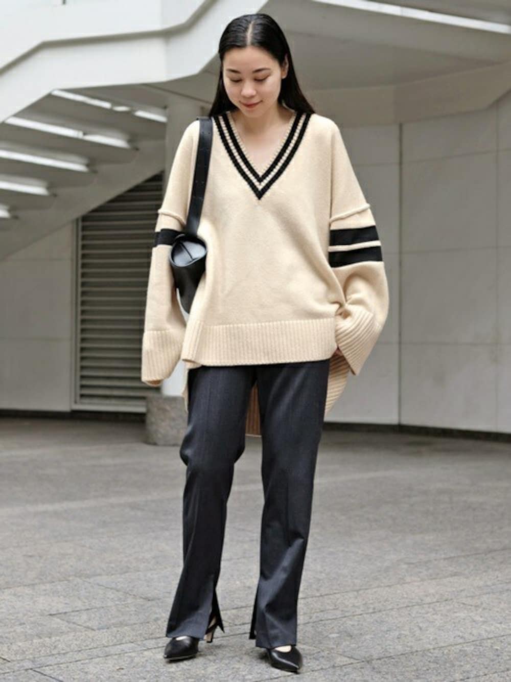 ホワイト系のニット/セーター、グレー系のスラックス、ブラック系のパンプスを着用したレディースの秋コーディネートの1枚目の写真