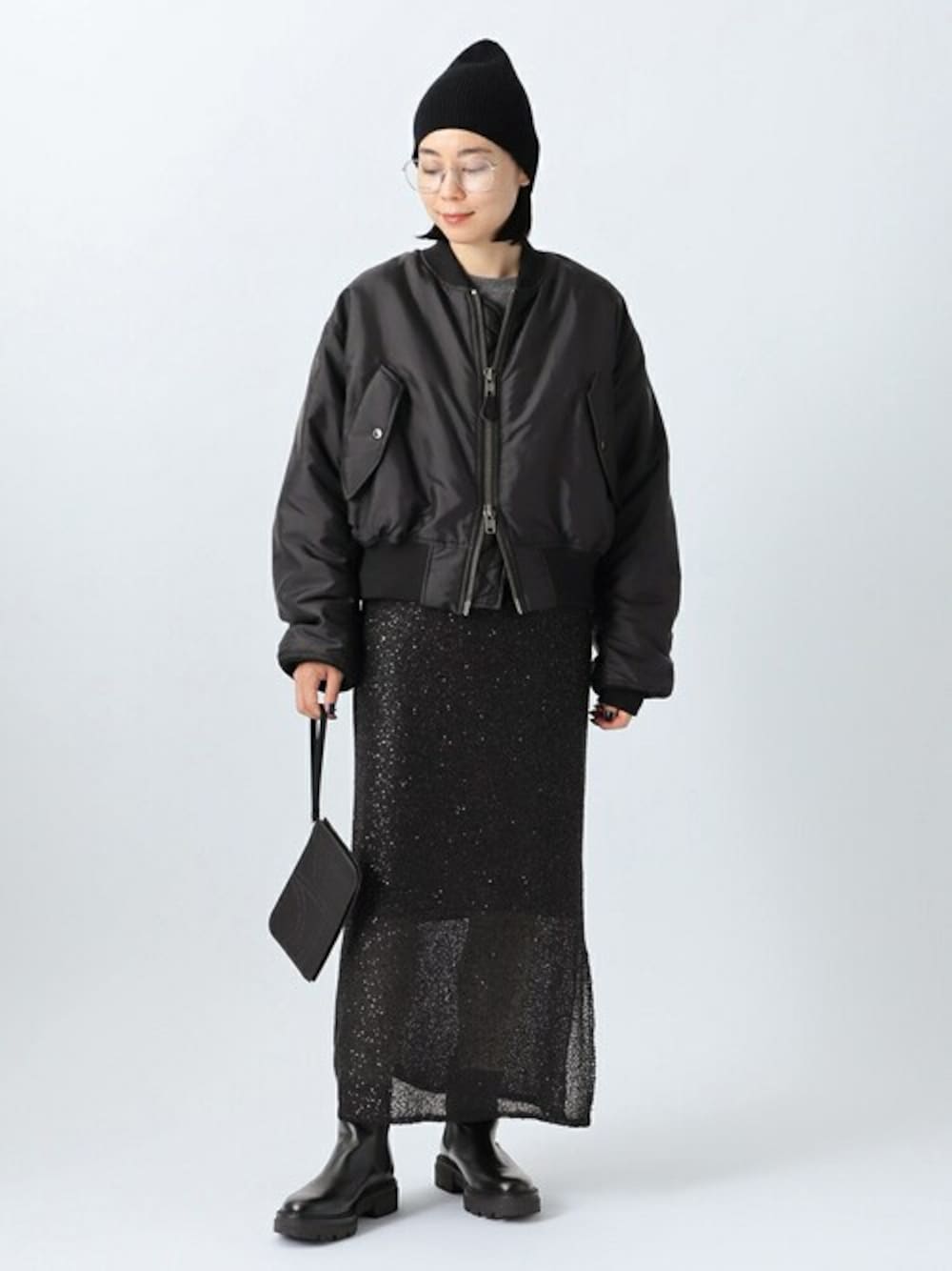 ブラック系のMA-1、グレー系のニット/セーター、ブラック系のスカートを着用したレディースの秋コーディネートの1枚目の写真