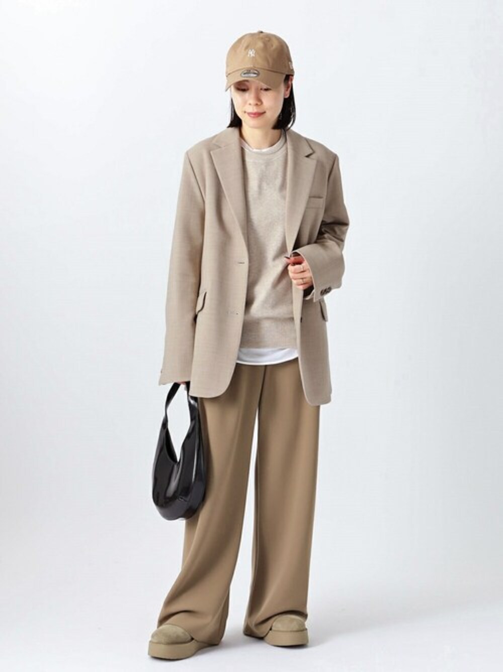 ベージュ系のテーラードジャケット、ベージュ系のスラックス、ベージュ系のニット/セーターを着用したレディースの秋コーディネートの1枚目の写真