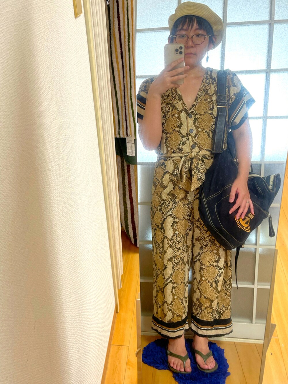 ブラック系のバックパック/リュック、ベージュ系のオールインワン・サロペット、グリーン系のサンダルを着用したレディースの夏コーディネートの1枚目の写真