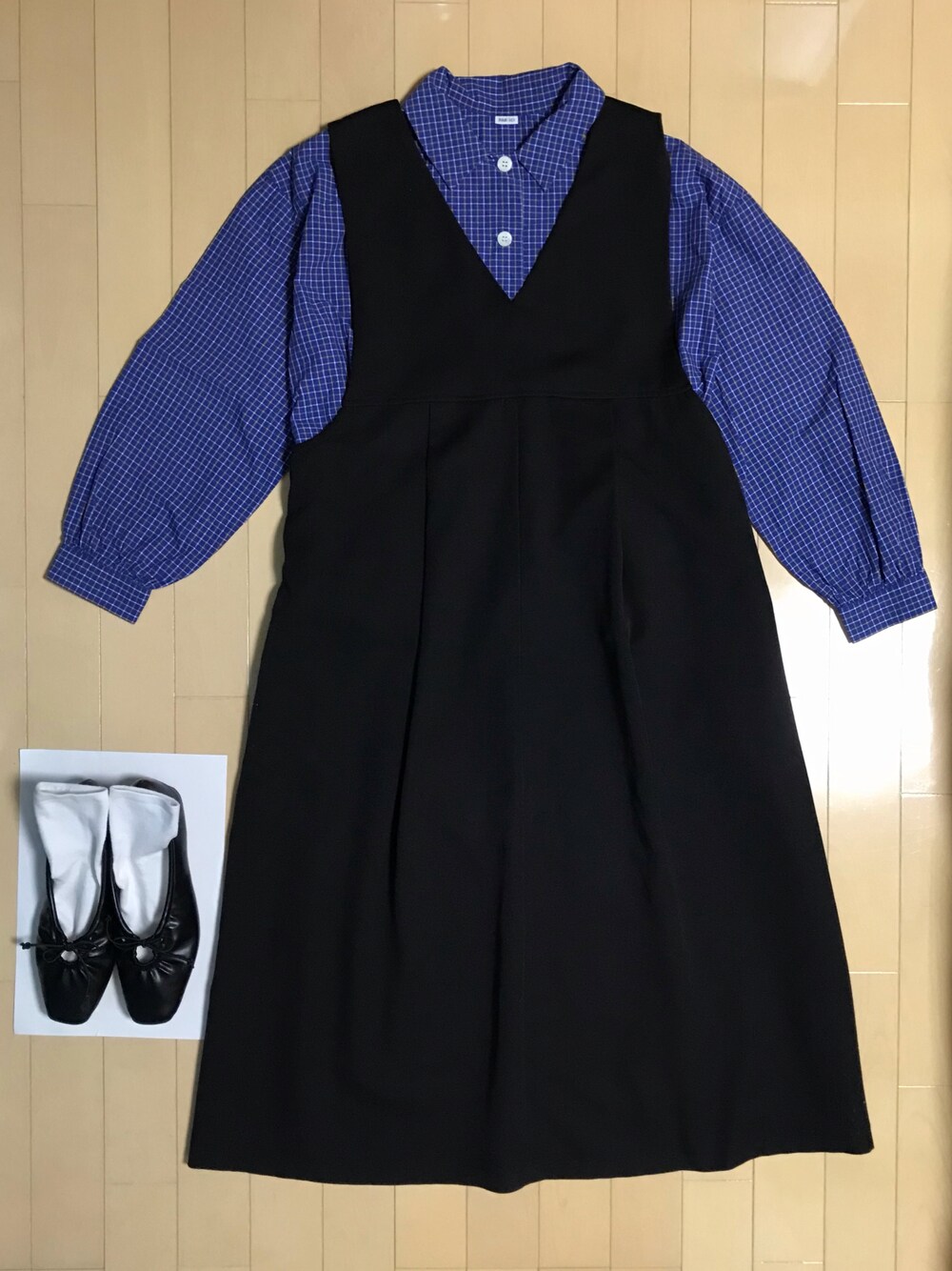 ブルー系のシャツ/ブラウス、ブラック系のジャンパースカート、ブラック系のシューズを着用したレディースの春コーディネートの1枚目の写真