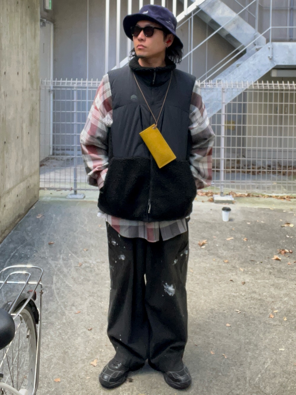 レッド系のシャツ/ブラウス、ブラック系のダウンベスト、ブラック系のチノパンツを着用したメンズの秋コーディネートの1枚目の写真