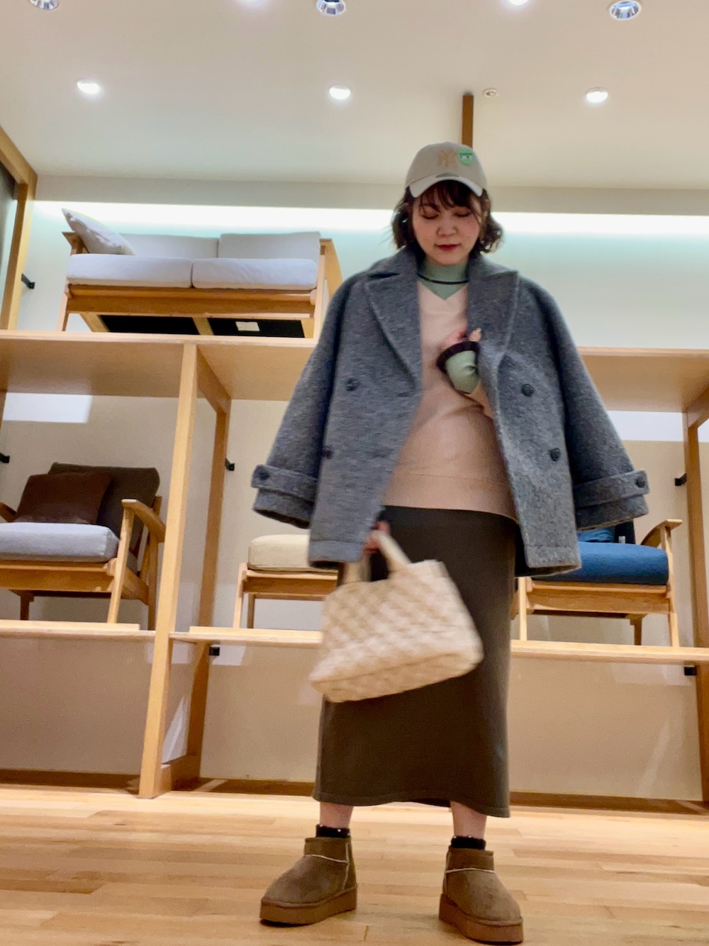 ホワイト系のハンドバッグ、グレー系のその他アウター、グリーン系のニット/セーターを着用したレディースの秋コーディネートの1枚目の写真