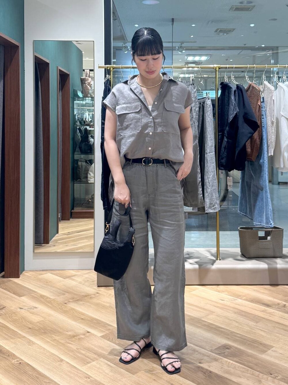 グレー系のその他パンツ、グレー系のシャツ/ブラウス、ブラック系のショルダーバッグを着用したレディースの夏コーディネートの1枚目の写真