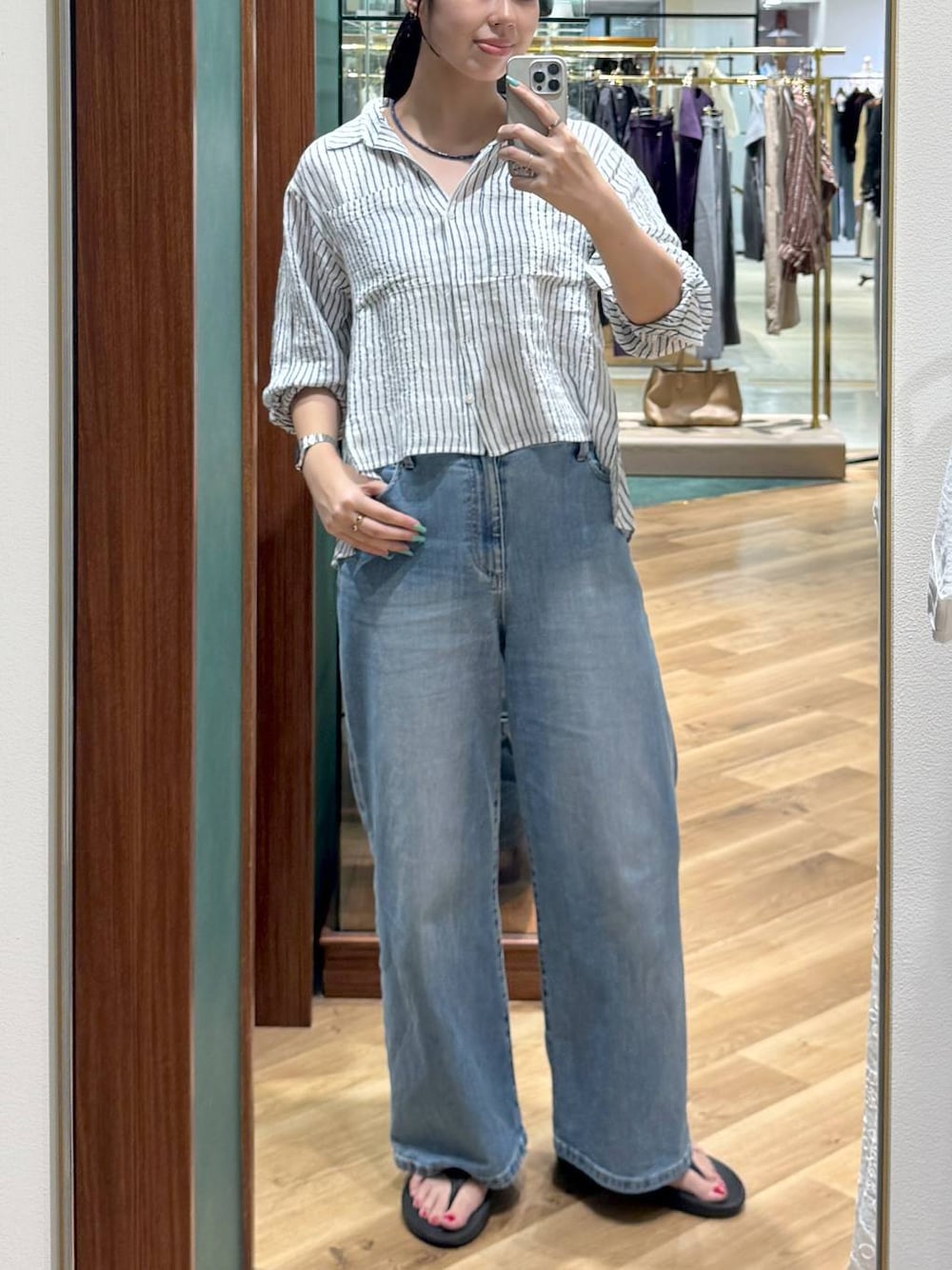 ホワイト系のシャツ/ブラウス、ブルー系のデニムパンツ、ブルー系のネックレスを着用したレディースの夏コーディネートの1枚目の写真