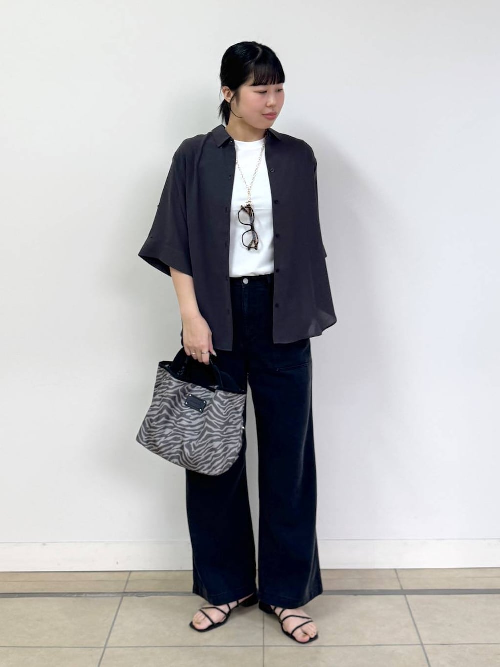 グレー系のトートバッグ、グレー系のシャツ/ブラウス、グレー系のデニムパンツを着用したレディースの春コーディネートの1枚目の写真