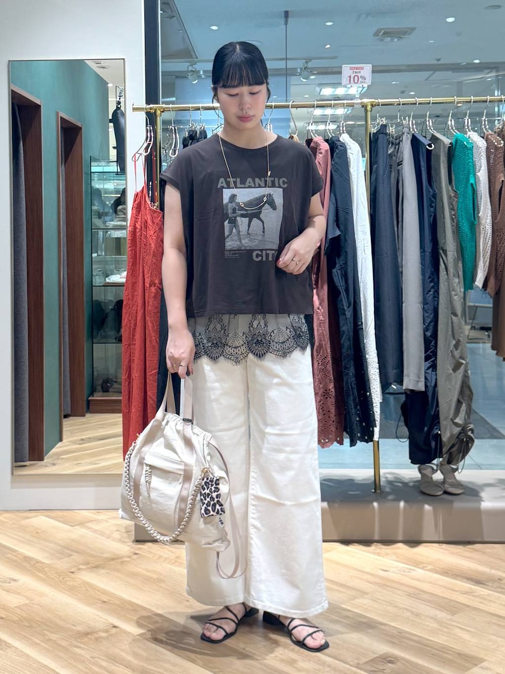 ブラウン系のTシャツ/カットソー、ホワイト系のデニムパンツ、ベージュ系のバックパック/リュックを着用したレディースの夏コーディネートの1枚目の写真