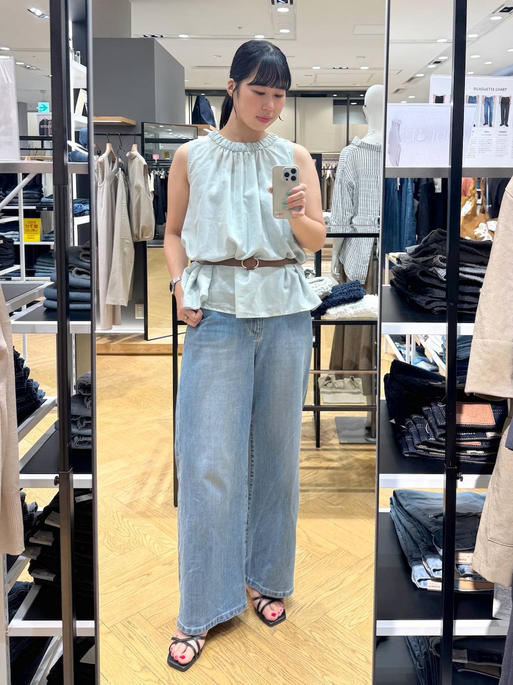 ブルー系のデニムパンツ、グリーン系のシャツ/ブラウス、ブラウン系のベルトを着用したレディースの夏コーディネートの1枚目の写真