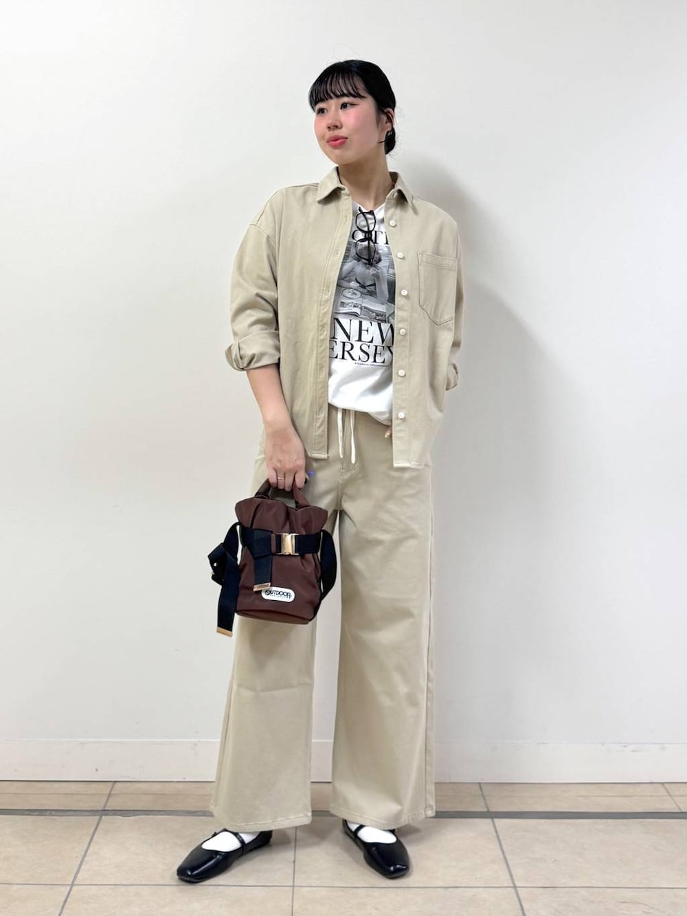 ベージュ系のシャツ/ブラウス、ブラウン系のショルダーバッグ、ベージュ系のデニムパンツを着用したレディースの冬コーディネートの1枚目の写真