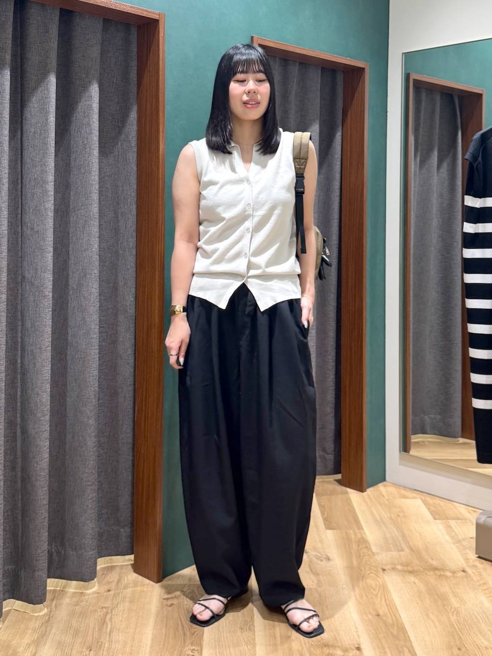 ブラック系のその他パンツ、グリーン系のバックパック/リュック、ベージュ系のベストを着用したレディースの春コーディネートの1枚目の写真