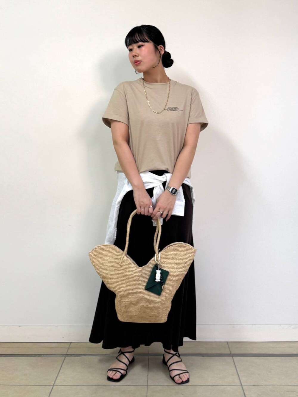 ホワイト系のシャツ/ブラウス、ベージュ系のTシャツ/カットソー、ブラウン系のスカートを着用したレディースの春コーディネートの1枚目の写真