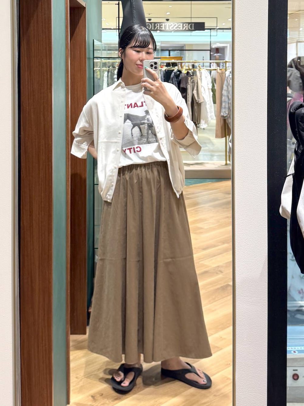 ホワイト系のTシャツ/カットソー、ベージュ系のスカート、ブラック系のショルダーバッグを着用したレディースの夏コーディネートの1枚目の写真