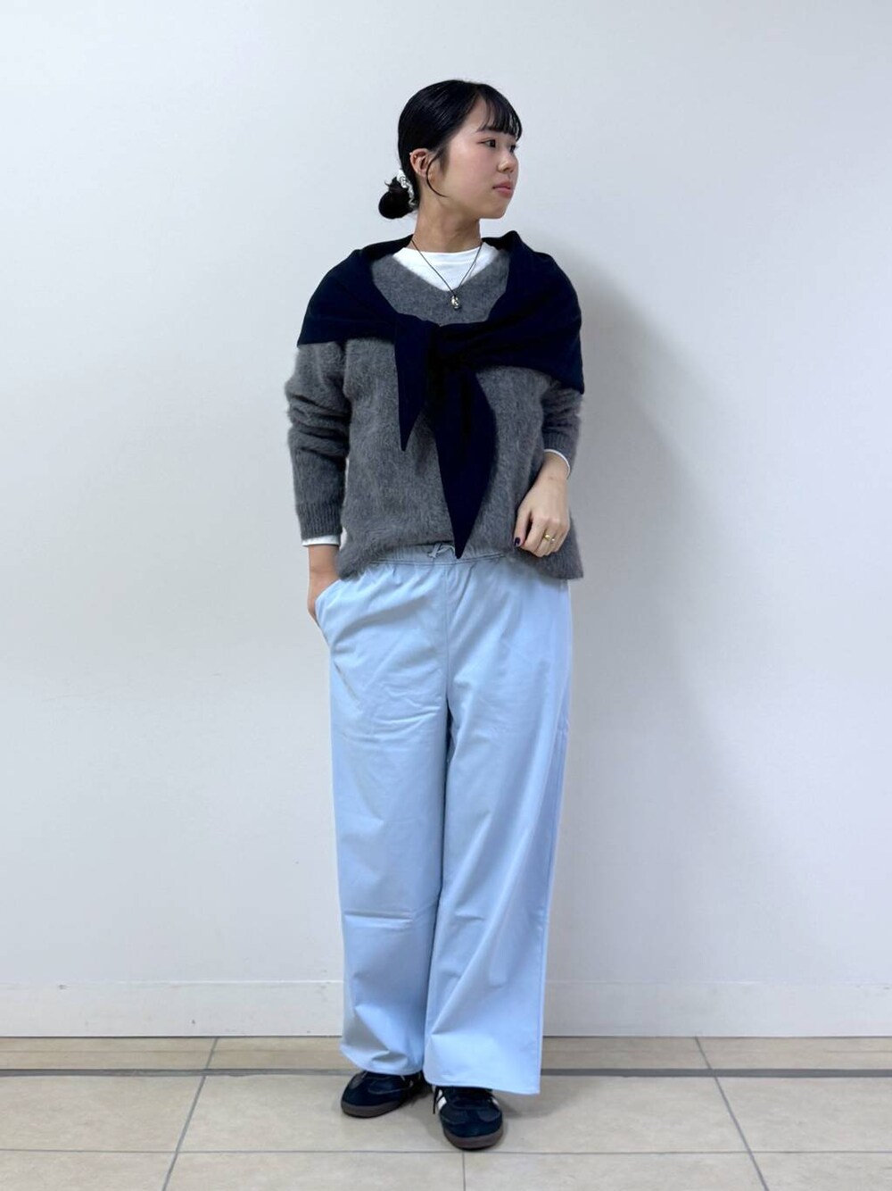 グレー系のニット/セーター、ホワイト系のTシャツ/カットソー、ブルー系のその他パンツを着用したレディースの秋コーディネートの1枚目の写真