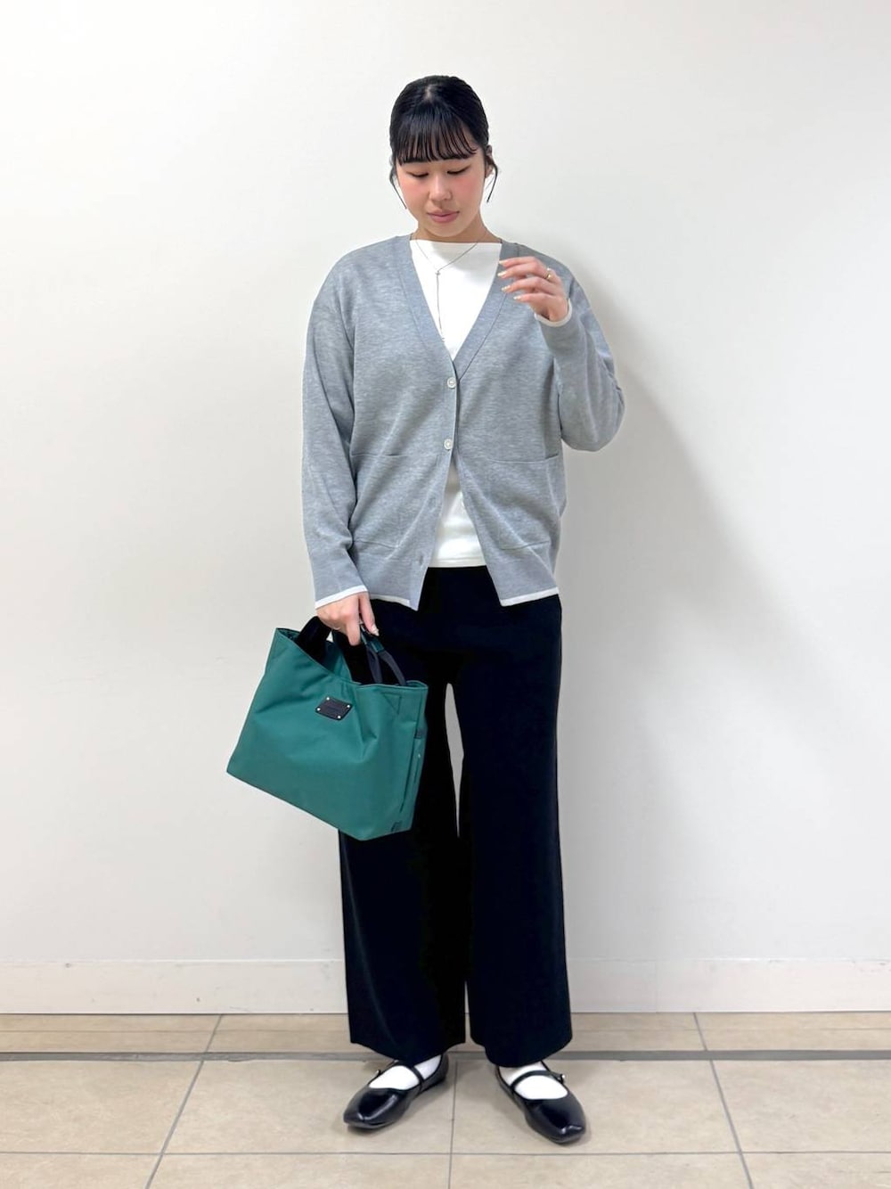 ブラック系のその他パンツ、グリーン系のトートバッグ、ホワイト系のTシャツ/カットソーを着用したレディースの冬コーディネートの1枚目の写真