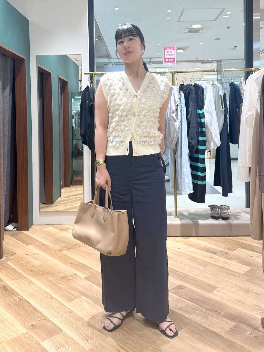 イエロー系のトートバッグ、ブルー系のその他パンツ、ホワイト系のニット/セーターを着用したレディースの春コーディネートの1枚目の写真