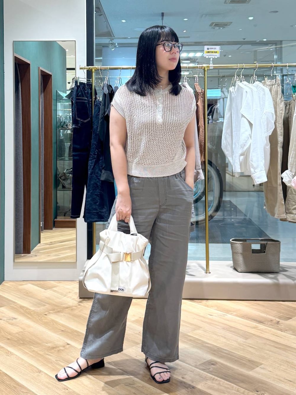 ホワイト系のショルダーバッグ、グレー系のその他パンツ、ベージュ系のニット/セーターを着用したレディースの夏コーディネートの1枚目の写真