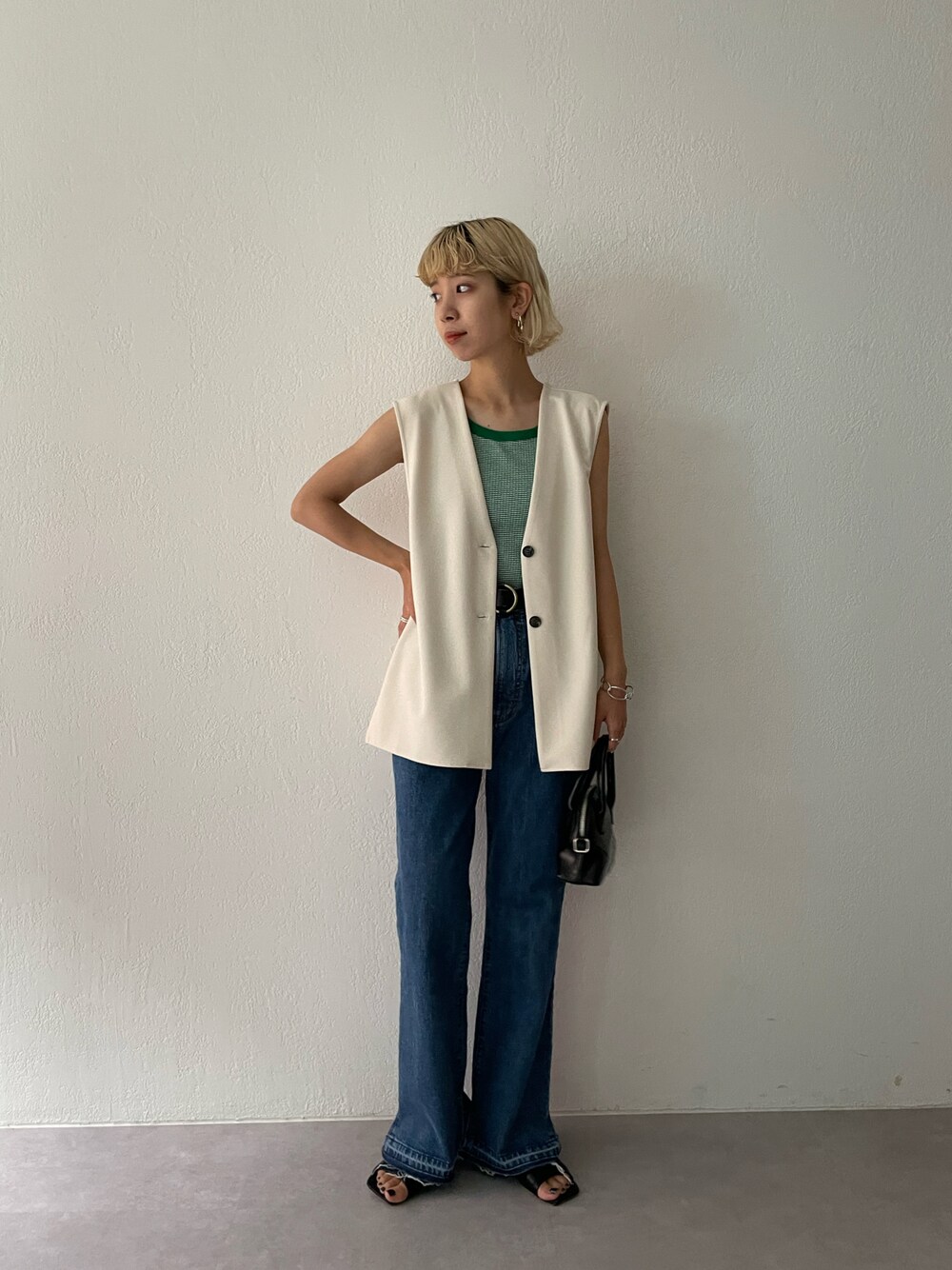 ホワイト系のベスト、グリーン系のタンクトップを着用したレディースの夏コーディネートの1枚目の写真