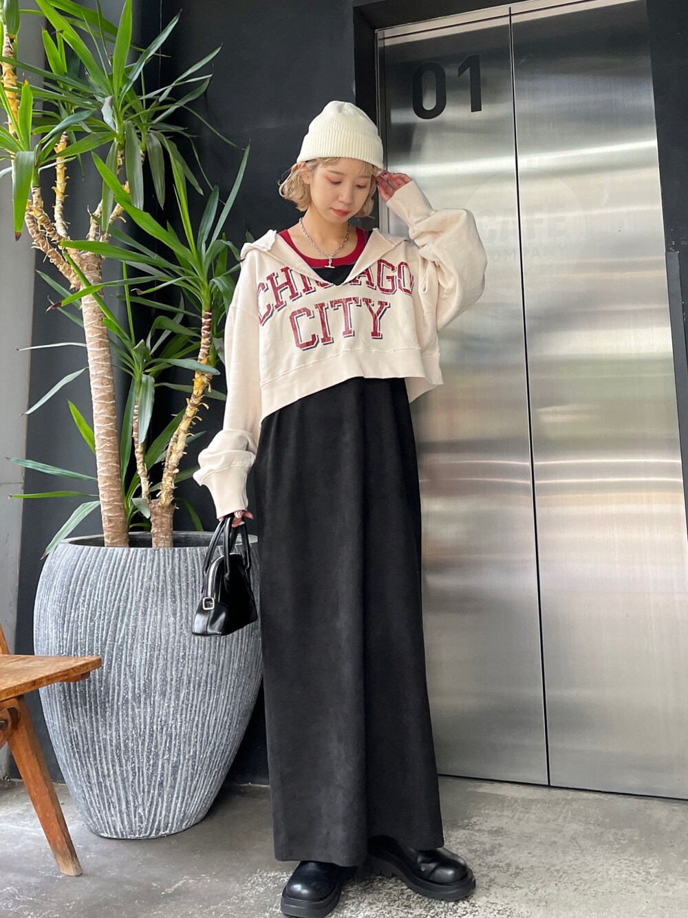 ホワイト系のパーカー、ブラック系のワンピース、ホワイト系のニットキャップ/ビーニーを着用したレディースの秋コーディネートの1枚目の写真