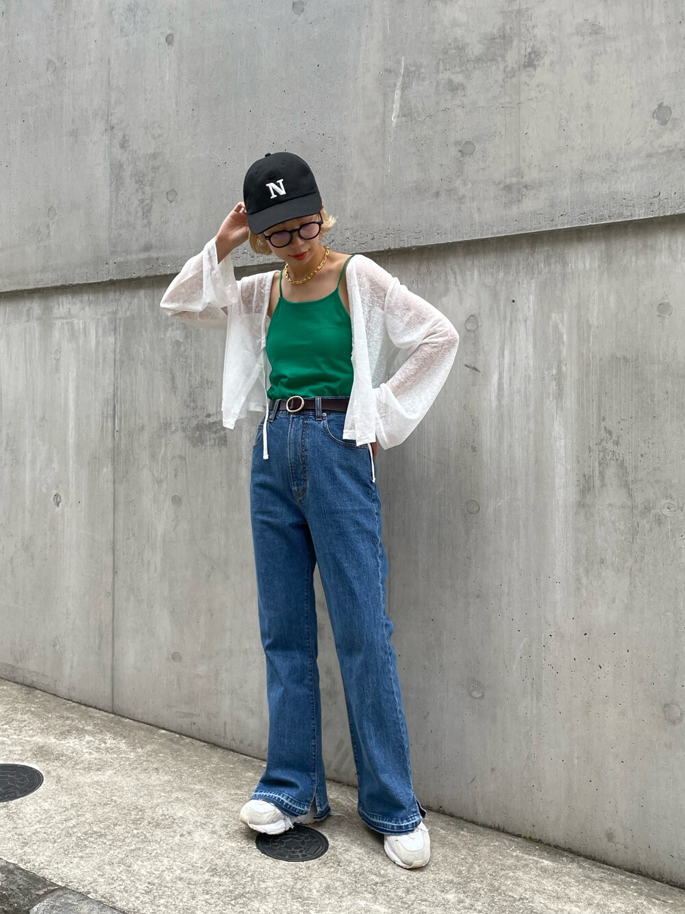 ホワイト系のカーディガン/ボレロ、グリーン系のキャミソール、ブラック系のキャップを着用したレディースの夏コーディネートの1枚目の写真