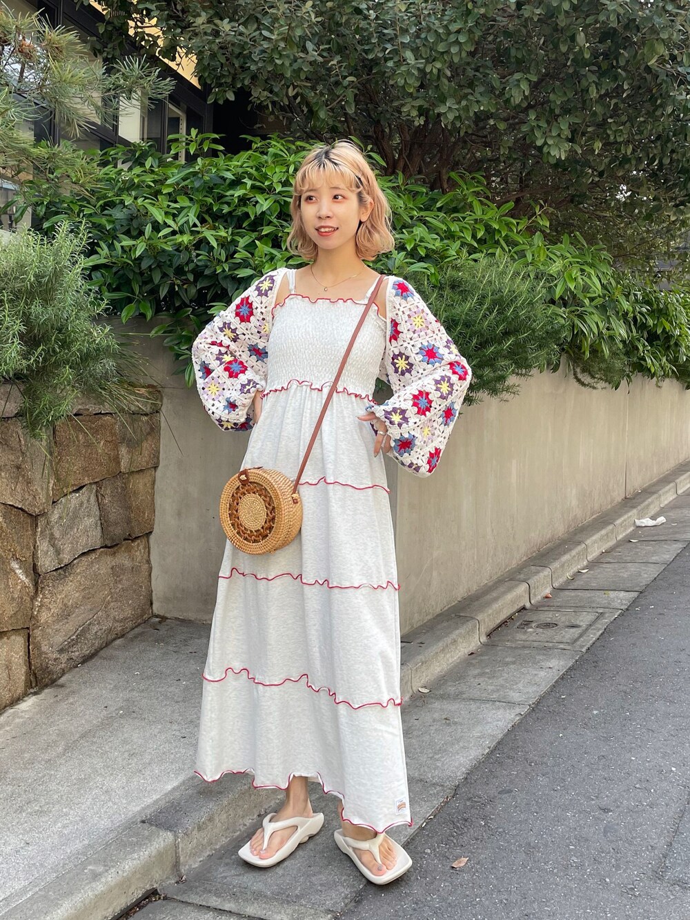 ホワイト系のワンピース、ベージュ系のかごバッグ、ホワイト系のシューズを着用したレディースの春コーディネートの1枚目の写真