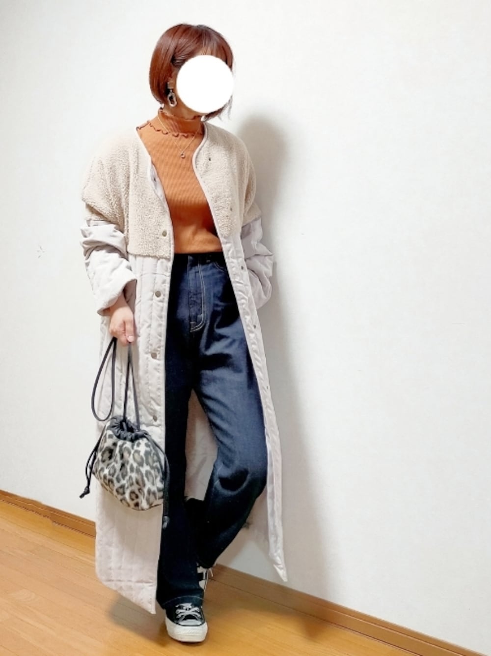 グレー系のノーカラーコート、ブルー系のデニムパンツ、ベージュ系のショルダーバッグを着用したレディースの秋コーディネートの1枚目の写真