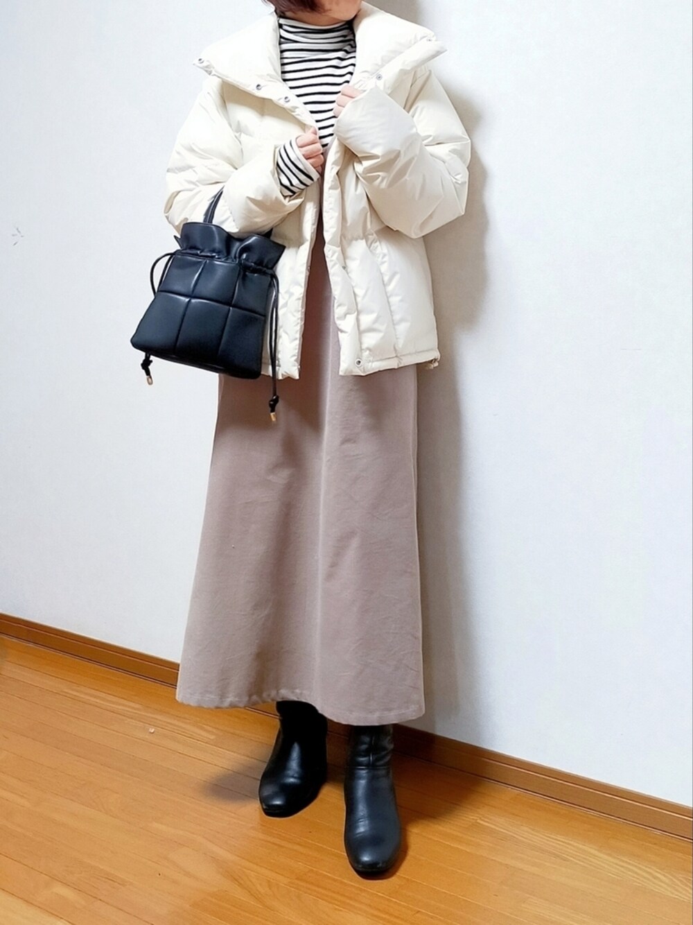 ホワイト系のダウンジャケット/コート、ホワイト系のニット/セーター、ベージュ系のワンピースを着用したレディースの冬コーディネートの1枚目の写真