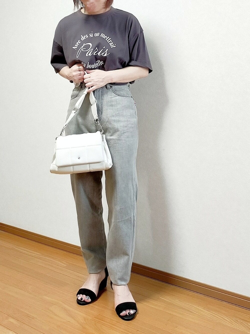 グレー系のTシャツ/カットソー、ベージュ系のデニムパンツ、ホワイト系のショルダーバッグを着用したレディースの夏コーディネートの1枚目の写真