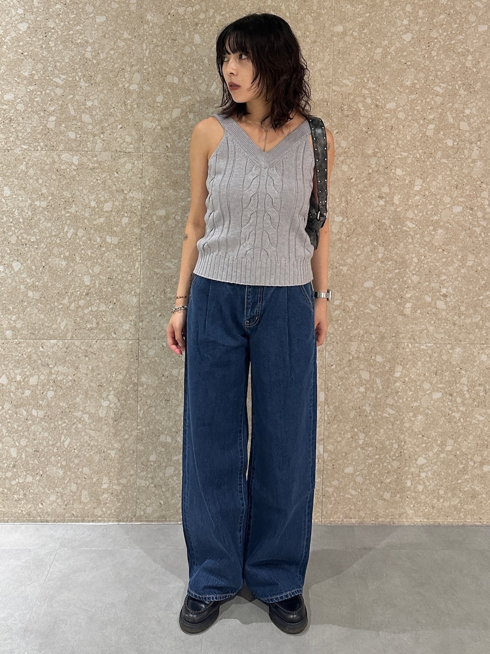 ブルー系のデニムパンツ、グレー系のキャミソール、ブラック系のショルダーバッグを着用したレディースの夏コーディネートの1枚目の写真