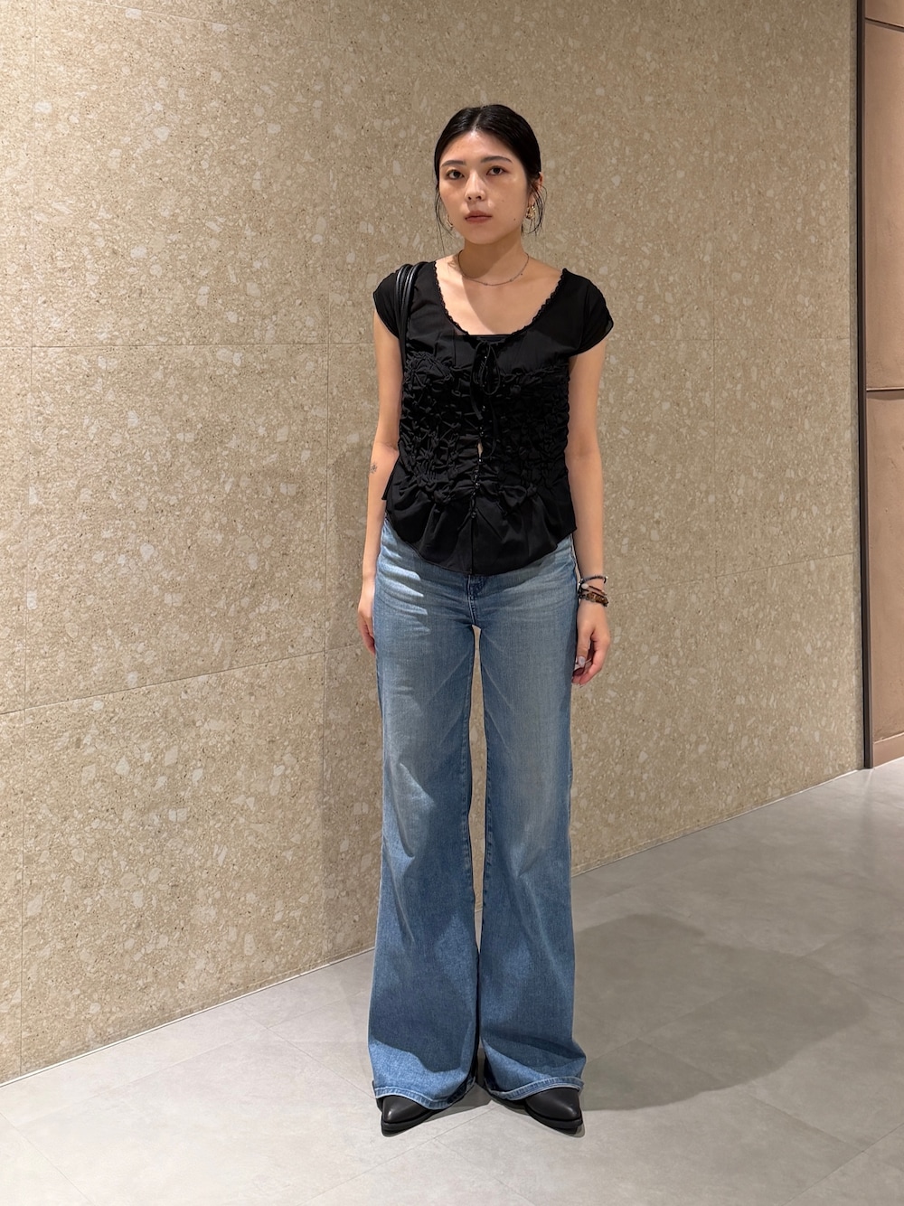 ブラック系のTシャツ/カットソー、ブルー系のデニムパンツ、ブラック系のブーツを着用したレディースの夏コーディネートの1枚目の写真