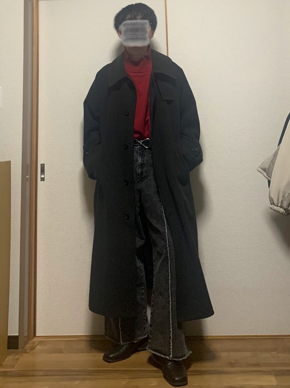 ブラウン系のステンカラーコート、レッド系のニット/セーター、ブラック系のデニムパンツを着用したメンズの冬コーディネートの1枚目の写真