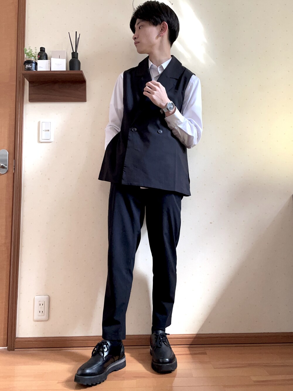 ブラック系のベスト、ホワイト系のシャツ/ブラウス、ブラック系のパンツを着用したメンズの春コーディネートの1枚目の写真