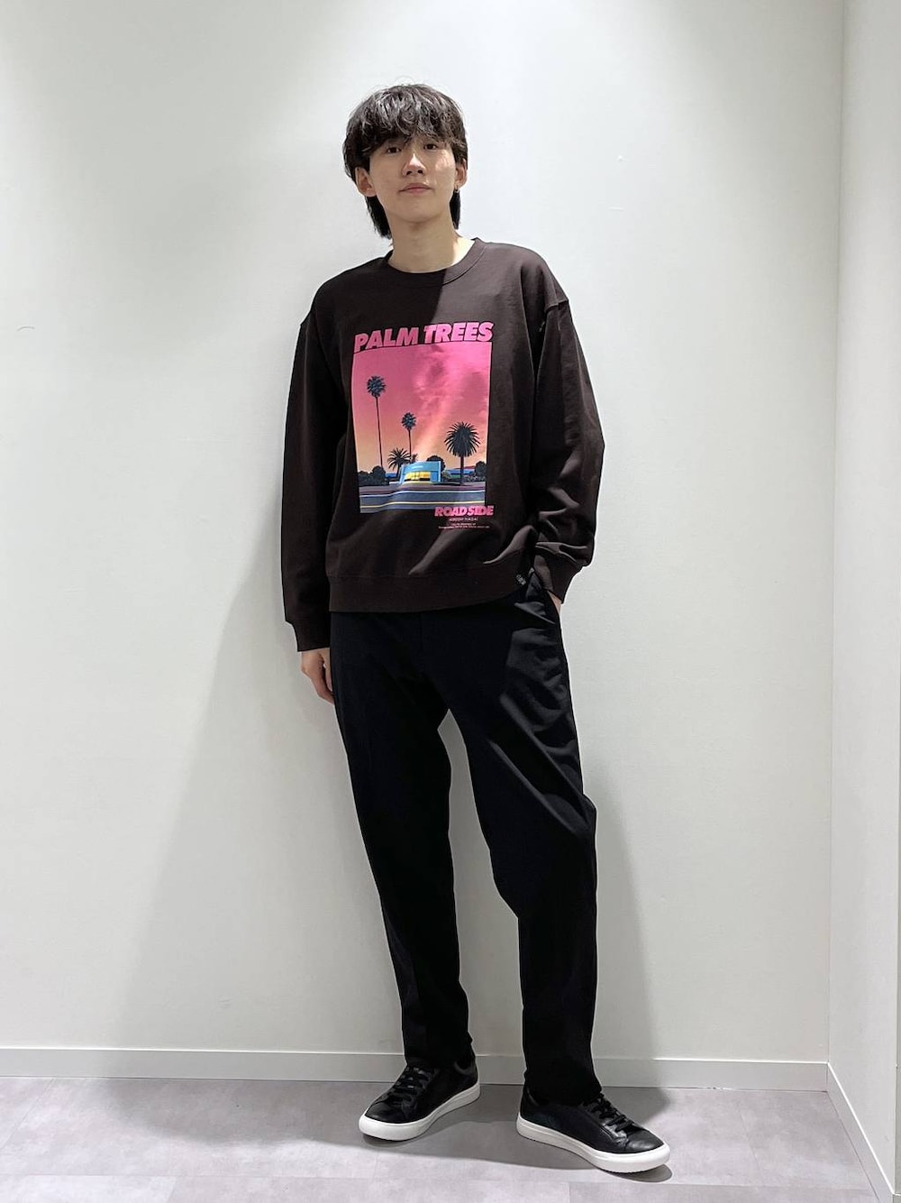 ブラック系のスラックス、ブラウン系のTシャツ/カットソー、ブラック系のスニーカーを着用したメンズの秋コーディネートの1枚目の写真