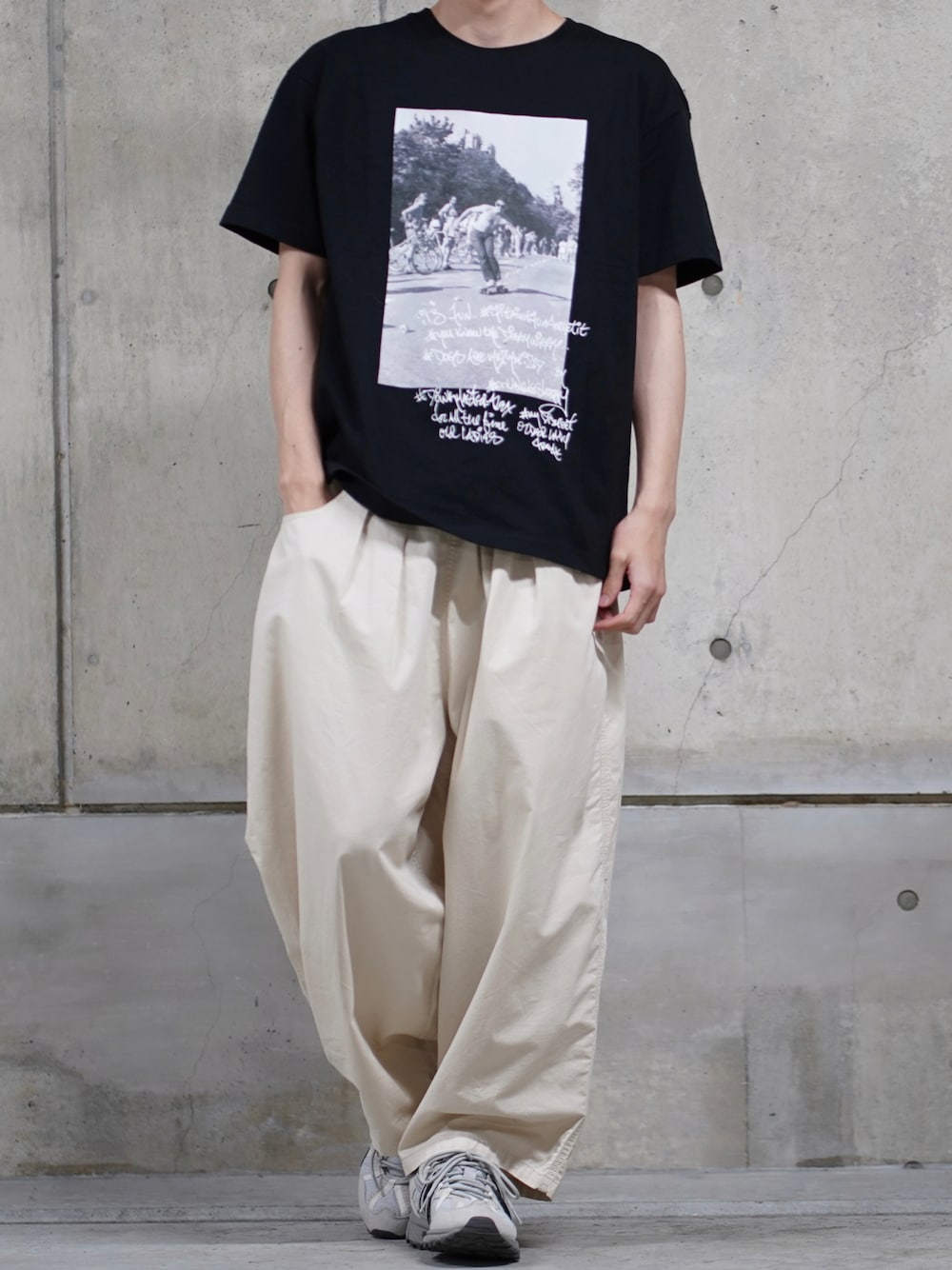 「休日スタイル、フォトT、ad、ゆるコーデ、白パンツ、ワイドパンツ、スニーカー、スニーカーコーデ、メンズコーデ、夏コーデ、シンプルコーデ、モノトーン」｜「ITEMS URBANRESEARCHのRICKY POWELL Photo Tshirts（Tシャツ/カットソー、ブラック系）」を使った、なおゑさん（メンズ・180cm）の春コーディネートの1枚目の写真