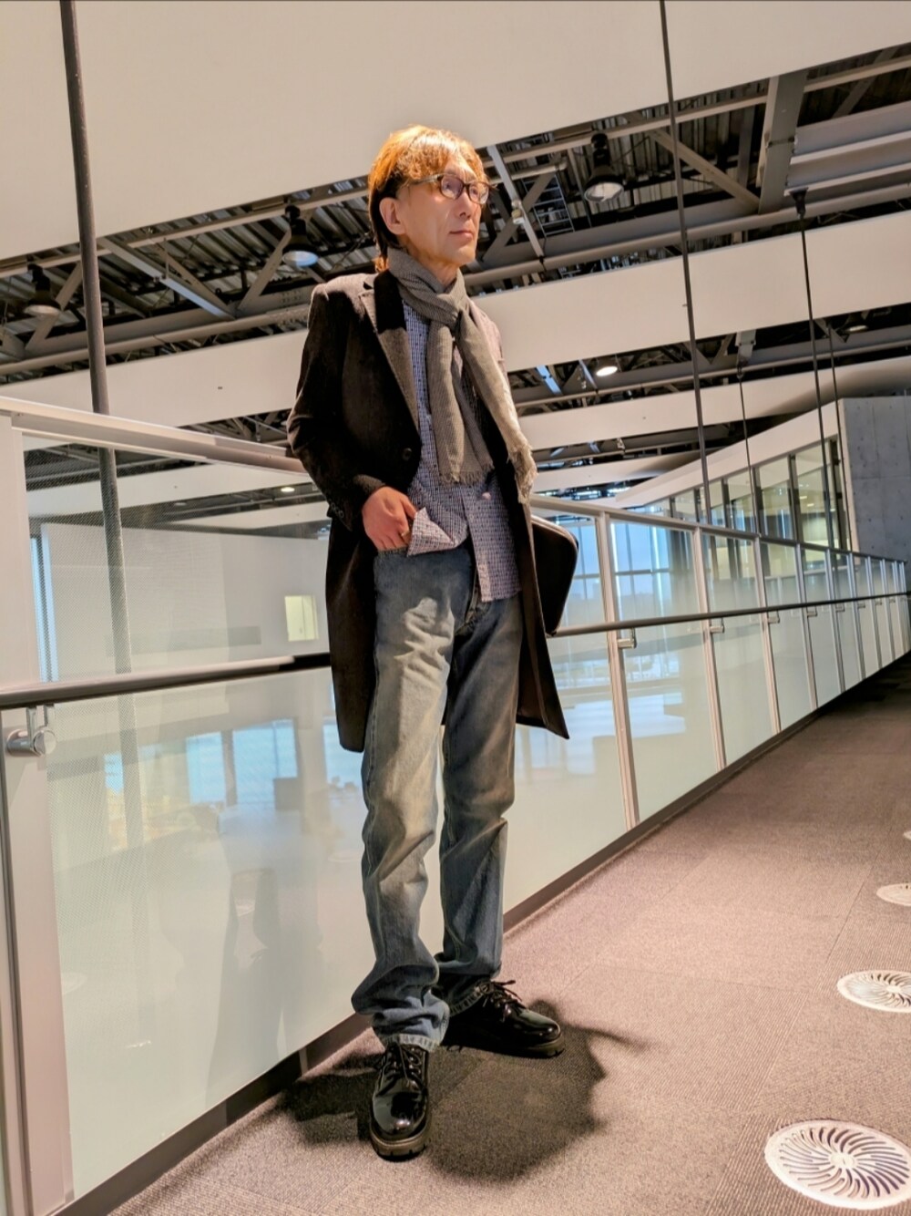 グレー系のチェスターコート、ブルー系のデニムパンツ、ブルー系のシャツ/ブラウスを着用したメンズの冬コーディネートの1枚目の写真