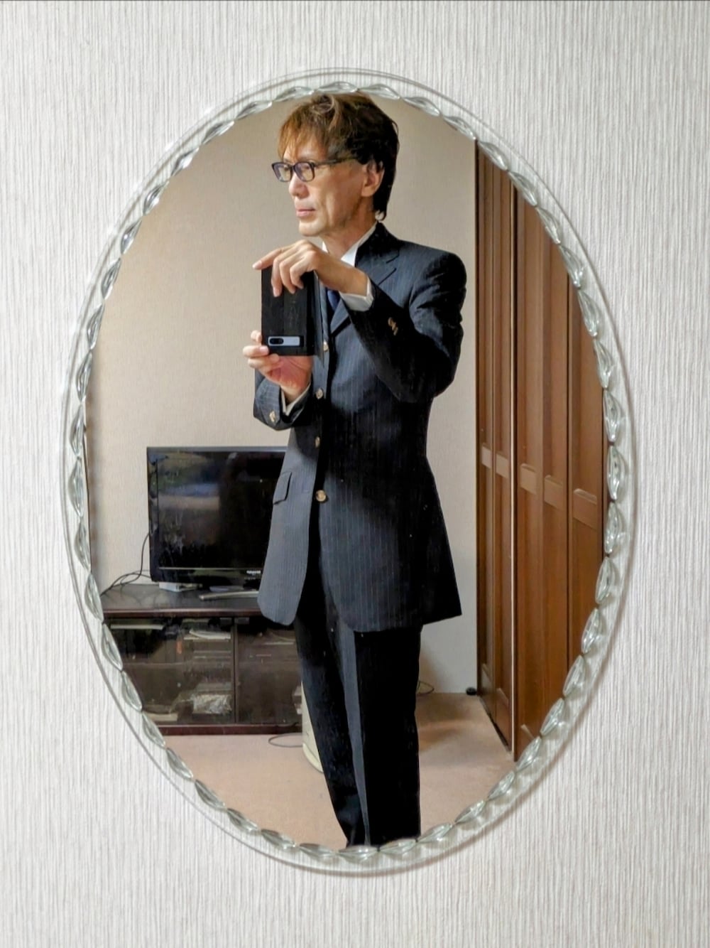 グレー系のスーツジャケット、グレー系のスーツパンツ、ホワイト系のシャツ/ブラウスを着用したメンズの秋コーディネートの1枚目の写真