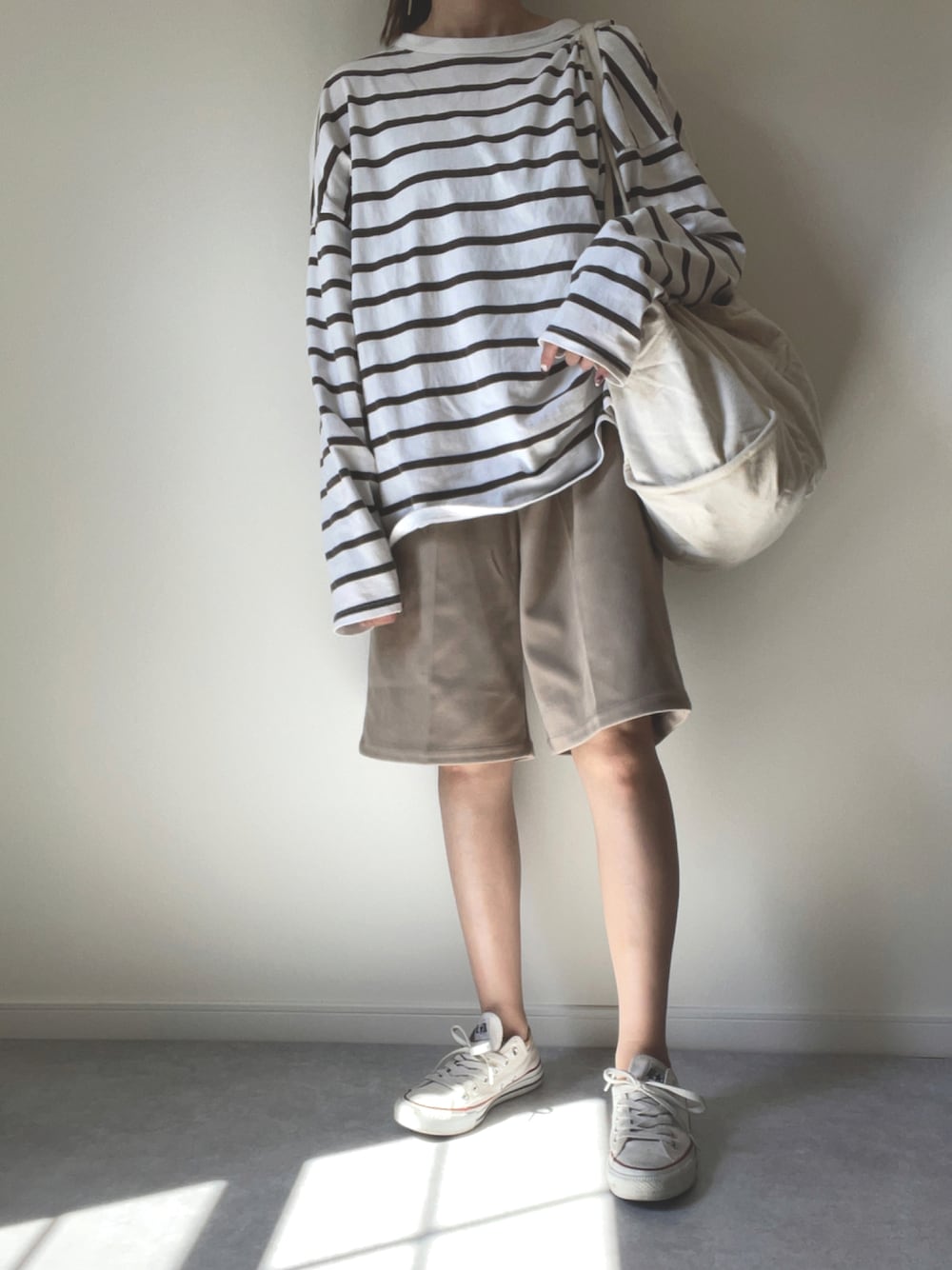 ベージュ系のその他パンツ、ホワイト系のスニーカー、ブラウン系のTシャツ/カットソーを着用したレディースの秋コーディネートの1枚目の写真