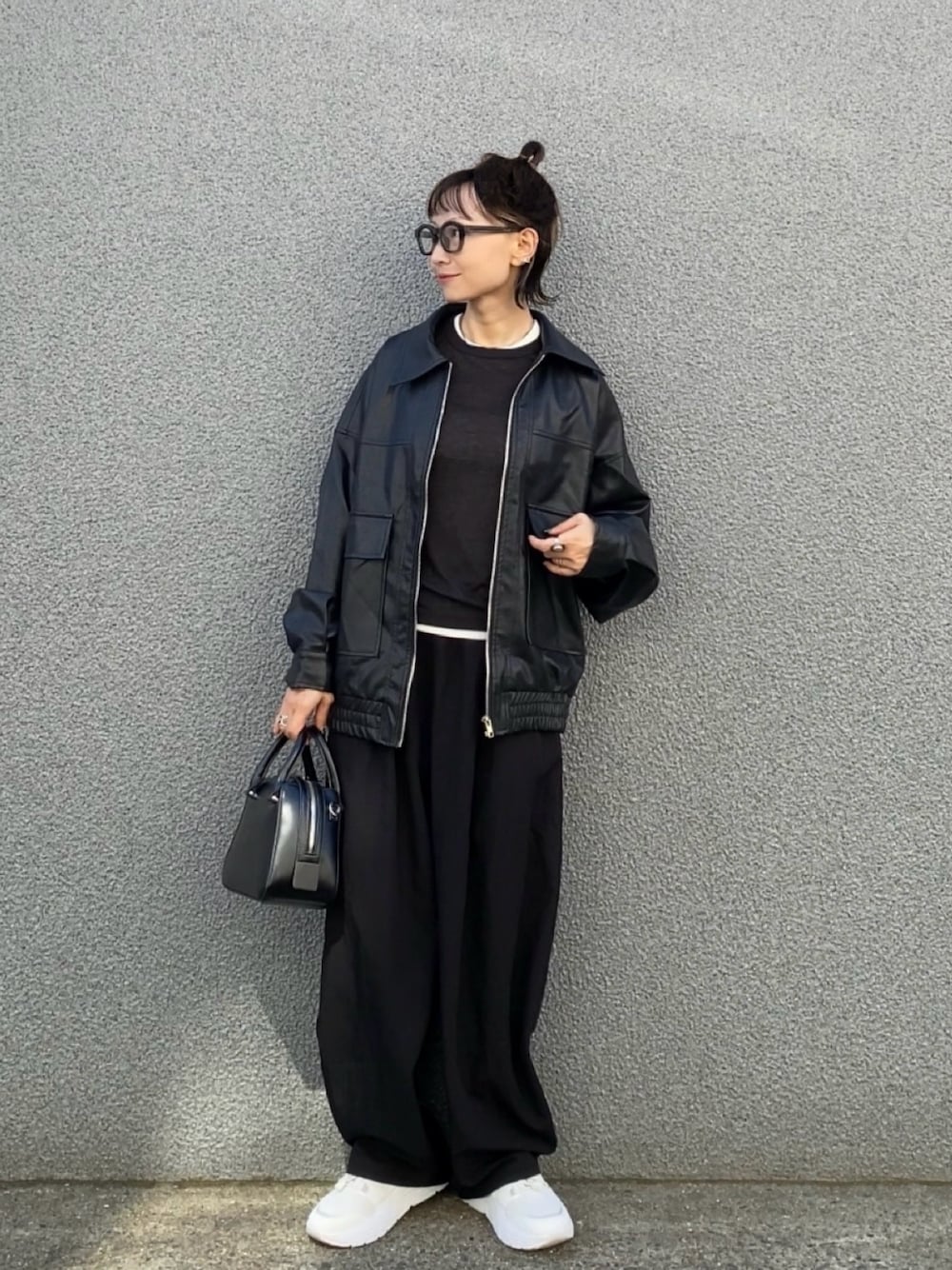 ブラック系のその他パンツ、ブラック系のボストンバッグ、ホワイト系のTシャツ/カットソーを着用したレディースの秋コーディネートの1枚目の写真