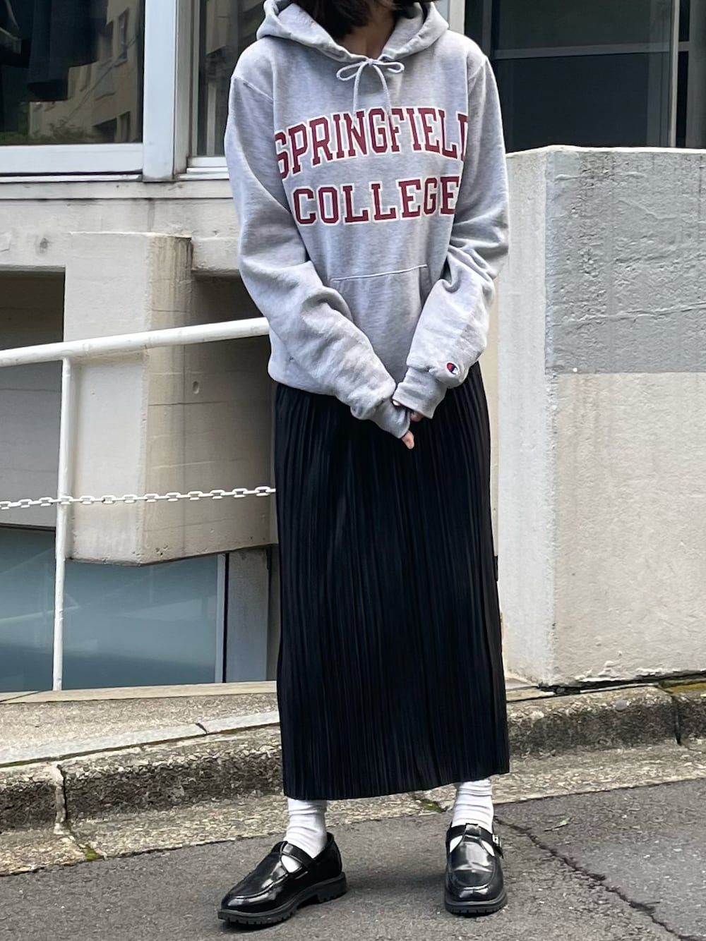 ブラック系のスカート、ブラック系のローファーを着用したレディースの秋コーディネートの1枚目の写真