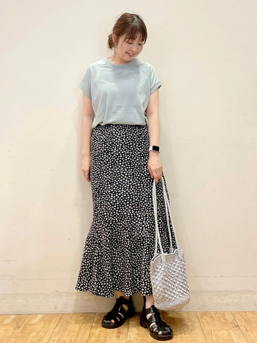 グリーン系のTシャツ/カットソー、ブラック系のスカート、シルバー系のトートバッグを着用したレディースの夏コーディネートの1枚目の写真
